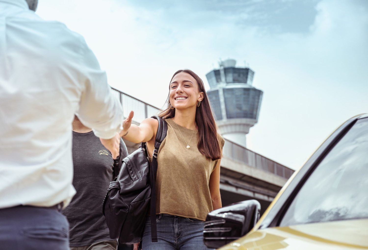 Una giovane donna accoglie gli arrivi all'aeroporto.